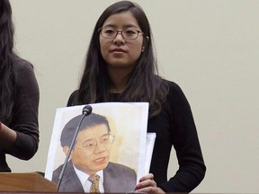 Ti-Anna Wang, holds a photo of her father Wang Bingzhang in a file photo.