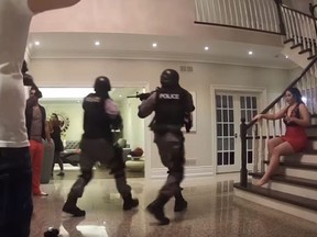 People dressed in gear emulating Toronto Police enter a home on in a video posted to YouTube Jan. 4, 2019.