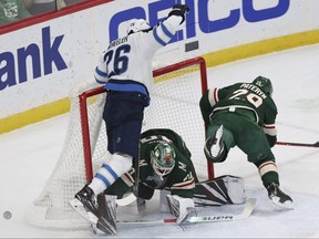 Winnipeg Jets' Blake Wheeler crashes into Minnesota Wild's goalie Devan Dubnyk after trying to score a goal in the first period of an NHL hockey game Thursday in St. Paul, Minn. (AP)