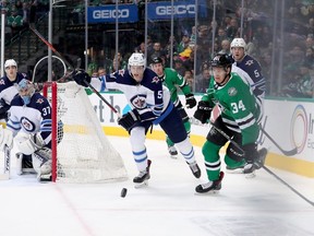 Denis Gurianov (34) of the Dallas Stars battles for the puck against Tyler Myers (57) and Dmitry Kulikov (5) of the Winnipeg Jets in the second period at American Airlines Center on Saturday in Dallas, Texas.