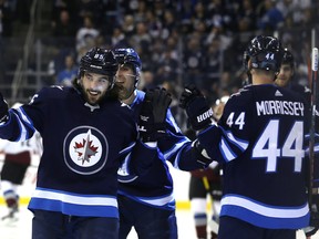 Jets forward Mathieu Perreault (left) celebrates his first-period goal against the Avalanche on Tuesday.