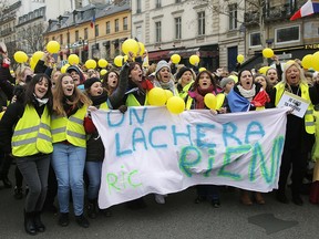 Women wearing yellow vests and holding yellow balloons march during a protest in Paris, Sunday, Jan. 6, 2019.  (AP Photo//Michel Euler)