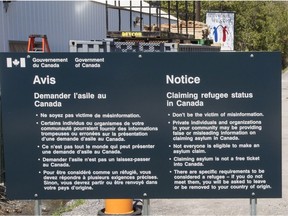 A sign warning asylum seekers is seen at the Canada-U.S. border at Roxham Rd. Wednesday May 9, 2018 in Champlain, N.Y.