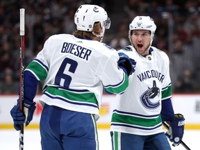 Brock Boeser is congratulated by Derrick Pouliot after his goal against the Colorado Avalanche in the first period at the Pepsi Center on Saturday.