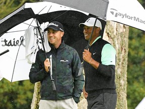 Justin Thomas (left) and Tiger Woods react to Woods’ birdie on the 12th hole during the second round of the Genesis Open at Riviera Country Club in Pacific Palisades, Calif., yesterday. Woods is nine shots off the lead.