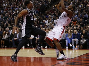 Raptors' Kawhi Leonard gets a shot off in front of San Antonio Spurs' DeMar DeRozan during Friday's game. (JACK BOLAND/Toronto Sun)
