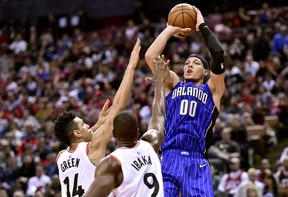 Raptors' Danny Green and Serge Ibaka try to defend a shot by Orlando Magic forward Aaron Gordon during Sunday's game. (THE CANADIAN PRESS)