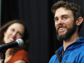 Travis Kauffman responds to questions during a news conference Thursday, Feb. 14, 2019, in Fort Collins, Colo., about his encounter with a mountain lion while running a trail just west of Fort Collins last week. Kaufman's girlfriend, Annie Bierbower, looks on at left.   (AP Photo/David Zalubowski)