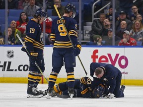 Buffalo Sabres Jake McCabe (19) and Jack Eichel (9) watch as Jeff Skinner (53) is attended to by a trainer during the second period of an NHL hockey game against the Washington Capitals, Saturday, Feb. 23, 2019, in Buffalo N.Y. (AP Photo/Jeffrey T. Barnes)
