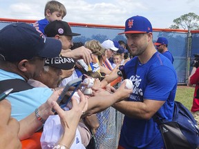 New York Mets' Tim Tebow signs autographs at spring training baseball practice Saturday, Feb. 16, 2019, in Port St. Lucie, Fla. (AP Photo/Mike Fitzpatrick)