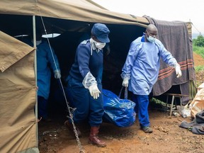 Mortuary staff carry a body bag with the recovered body of an artisanal miner during an ongoing rescue and recovery operation at the flooded Cricket gold mine near Kadoma, Zimbabwe, on February 17, 2019. - Rescue workers retrieved 24 bodies and eight survivors on February 16 from two flooded gold mines in Zimbabwe where officials fear dozens more illegal miners are still trapped, state television reported.