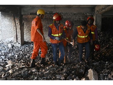 Bangladeshi firefighters inspect a burnt building after a fire tore through apartment blocks in Bangladesh's Dhaka on Feb. 21, 2019.