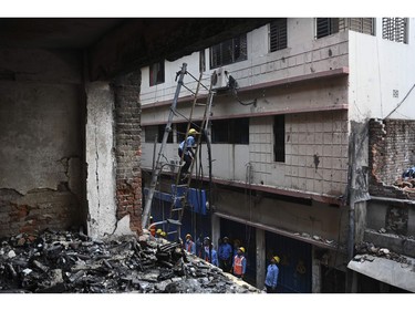 Bangladeshi firefighters cut burnt electric lines after a fire tore through apartment blocks in Bangladesh's capital Dhaka on Feb. 21, 2019.