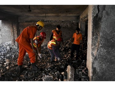 Bangladeshi firefighters inspect a burnt building after a fire tore through apartment blocks in Bangladesh's capital Dhaka on Feb. 21, 2019.