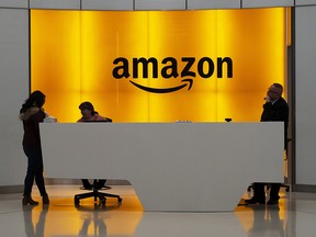 People stand in the lobby for Amazon offices Thursday, Feb. 14, 2019, in New York. (THE CANADIAN PRESS/AP-Mark Lennihan)