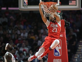 In this April 9, 2018, file photo, New Orleans Pelicans forward Anthony Davis dunks as Los Angeles Clippers forward Montrezl Harrell watches in Los Angeles. (AP Photo/Mark J. Terrill, File)