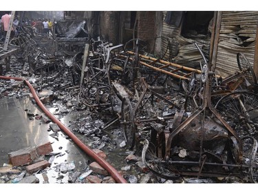 The wrangled and charred remains of rickshaws lie at the site of a late Wednesday night fire in Dhaka, Bangladesh, Thursday, Feb. 21, 2019.