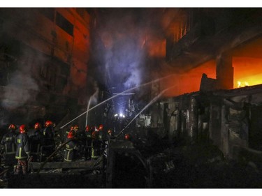 Firefighters work to douse flames in Dhaka, Bangladesh, Thursday, Feb. 21, 2019.