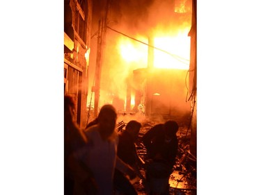 In this Wednesday, Feb. 20, 2019, photo, firefighters try to douse flames in Dhaka, Bangladesh.