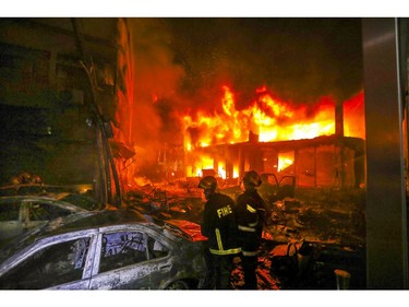 In this Wednesday, Feb. 20, 2019, photo, firefighters try to douse flames of a smoldering fire in Dhaka, Bangladesh.