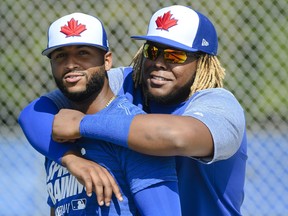 Toronto Blue Jays infielder Vladimir Guerrero Jr., right, hugs Richard Urena during baseball spring training in Dunedin, Fla. THE CANADIAN PRESS/Nathan Denette