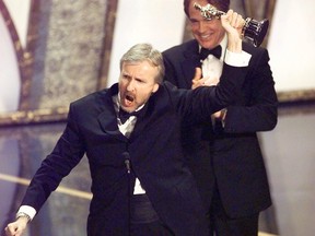 Director James Cameron raises his Oscar after winning in the Best Director category during the 70th Academy Awards at the Shrine Auditorium in Los Angeles on March 23, 1998.