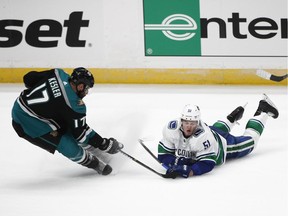 Vancouver Canucks' Troy Stecher, right, falls to the ice while competing for the puck with Anaheim Ducks' Ryan Kesler during the third period of an NHL hockey game Wednesday, Feb. 13, 2019, in Anaheim, Calif.