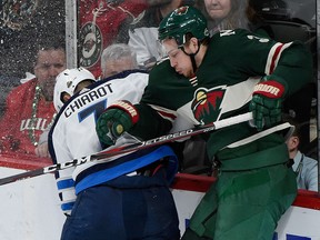 Charlie Coyle of the Minnesota Wild checks Ben Chiarot of the Winnipeg Jets into the boards during the 2018 Stanley Cup Playoffs at Xcel Energy Center on April 17, 2018 in St Paul, Minnesota. (Hannah Foslien/Getty Images)