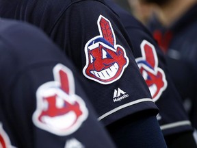 In this June 19, 2017 file photo, members of the Cleveland Indians wear uniforms featuring mascot Chief Wahoo as they stand on the field for the national anthem before a baseball game against the Baltimore Orioles in Baltimore.  The maker of Cleveland's ballpark mustard is removing the Chief Wahoo logo from its branding and packaging to maintain longstanding ties with the Cleveland Indians baseball team. The Indians have told official partners like Bertman Foods Co., the maker of Bertman Original Ballpark Mustard, those relationships can't continue unless they stop using Chief Wahoo.