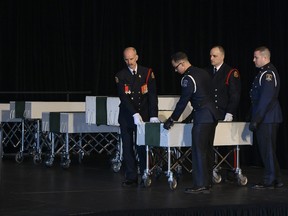 Members of the Halifax Fire and Police honour guard prepare to remove the caskets of the seven Barho siblings during the funeral for the Syrian refugee children in Halifax on Saturday, February 23, 2019. The siblings, who died in a house fire earlier in the week, are survived by their parents. THE CANADIAN PRESS/Darren Calabrese