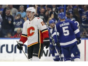 Calgary Flames left wing Matthew Tkachuk reacts as Tampa Bay Lightning players celebrate a goal during the first period of an NHL hockey game Tuesday in Tampa, Fla.