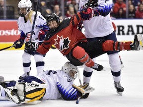 Canada forward Ann-Sophie Bettez is pushed over United States goalie Katie Burt after Canada scored during first period National Women's Team Rivalry Series hockey in Toronto on Thursday, Feb. 14, 2019.