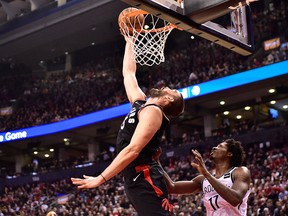 Toronto Raptors Marc Gasol makes a reverse dunk as Brooklyn Nets forward Ed Davis looks on during second half NBA basketball action in Toronto on Monday, Feb. 11, 2019.