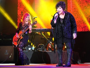 This June 17, 2013 file photo shows Nancy Wilson, left, and Ann Wilson of Heart performing on opening night of the Heartbreaker Tour at the Cruzan Amphitheater in West Palm Beach, Fla.