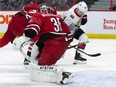 Hurricanes goaltender Curtis McElhinney looks on as Senators centre Jean-Gabriel Pageau  deflects the puck off his skate towards the net during the second period. The puck crossed the line, but the apparent goal was disallowed after an NHL video review.