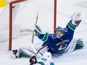 San Jose Sharks' Kevin Labanc, bottom, scores against Vancouver Canucks goalie Michael DiPietro during the second period on Monday night.