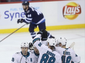 San Jose Sharks' Logan Couture (39) celebrates with his line after scoring as Winnipeg Jets' Josh Morrissey (44) skates off the ice during first period on Tuesday night. Josh Morrissey had been hurt prior to the goal. THE CANADIAN PRESS/Trevor Hagan