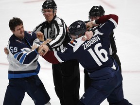 From left, Winnipeg Jets center Mark Scheifele is restrained by linesman Ryan Gibbons as Colorado Avalanche defenseman Nikita Zadorov is held back by linesman Lonnie Cameron as the players square of to fight in the third period in Denver on Wednesday night. (AP Photo/David Zalubowski)