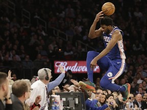 76ers' Joel Embiid leaps into the stands while chasing a loose ball during the second half of an NBA game against the Knicks, Wednesday, Feb. 13, 2019, in New York.