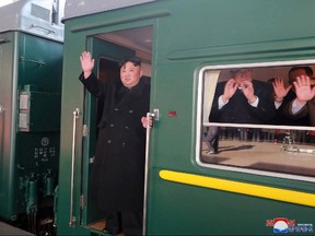 In this Saturday, Feb. 23, 2019, photo provided on Sunday, Feb. 24, 2019, by the North Korean government, North Korean leader Kim Jong Un waves from a train before leaving Pyongyang Station, North Korea, for Vietnam.