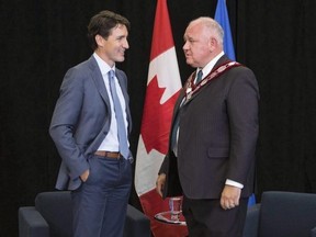 Prime Minister Justin Trudeau (left) speaks with Frank Scarpitti, Mayor of Markham during an event in Markham, Ont. on Friday, July 20, 2018.