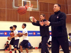 Former NBA star Mike Bibby works warm-ups with kids who received tips from the star at the Saddletowne YMCA during a fan fest event, on January 8, 2016. (Postmedia file photo)