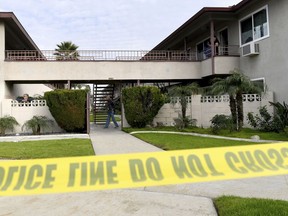 Residents mill about as Upland police investigate the scene, where police say a mother threw her young son from the second-story balcony of an apartment complex and then jumped herself as police arrived, in Upland, Calif., on Tuesday, Feb. 26, 2019.