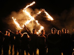 Members of the National Socialist Movement, one of the largest neo-Nazi groups in the U.S., hold a swastika burning after a rally on April 21, 2018 in Draketown, Ga.