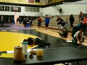A teen who fell through the roof during a high school wrestling match in Florida can be seen on the mat. (Video screen grab)