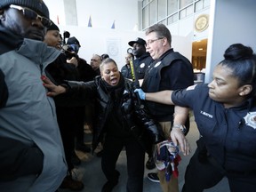 Corrections officers restrain a woman, centre, who was among dozens of family members of prisoners and protesters objecting to conditions in the Metropolitan Detention Center Sunday, Feb. 3, 2019.
