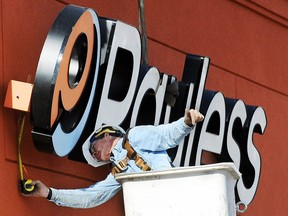 A crane operator installs a Payless Shoesource sign to the front of the store Thursday afternoon, Jan. 19, 2012, on Range Line Road in Joplin, Mo.