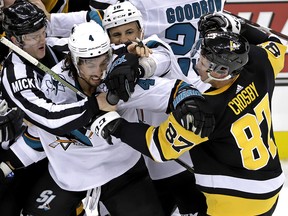 Pittsburgh Penguins' Sidney Crosby (87) and San Jose Sharks' Brenden Dillon (4) fight as Sharks' Micheal Haley (18) intervenes in Pittsburgh, Thursday, Feb. 21, 2019. (AP Photo/Gene J. Puskar)