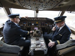 United Airlines Capt. Tommy Holloman, left, and Capt. Chuck Stewart demonstrate radio communications, right, and the Data Communications Data Comm technology, left, from the cockpit of an United Airlines Boeing 777 at Dulles International Airport Air Traffic Control Tower in Sterling, Va., Tuesday, Sept. 27, 2016. (AP Photo/Cliff Owen)
