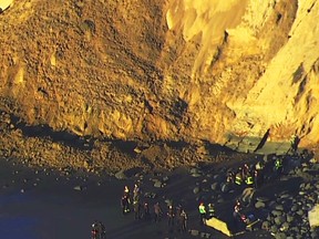 This photo from video provided by KGO-TV shows firefighters searching for a person who was thought to be buried by a landslide near a San Francisco beach Friday, Feb. 22, 2019. (KGO-TV via AP)